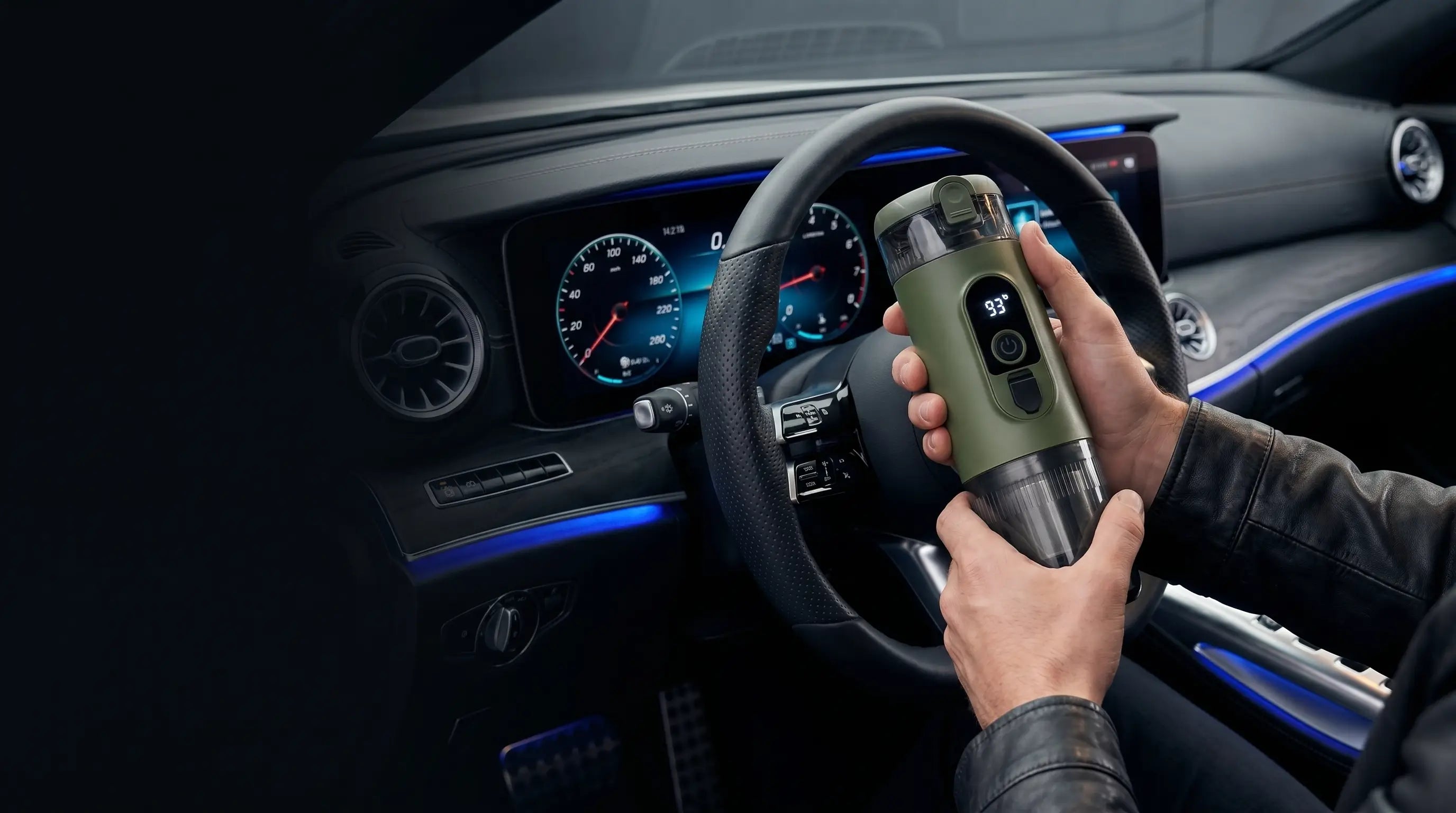 Yominobo portable espresso machine held in hand inside a car, with dashboard and steering wheel in background — brew café-quality coffee on the go