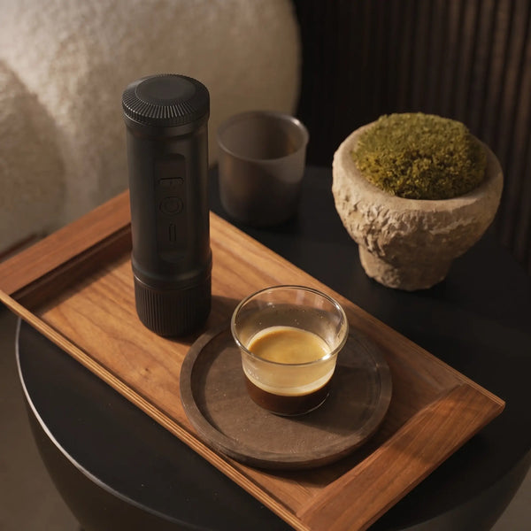 YomiNobo portable espresso machine with espresso cup on a wooden tray