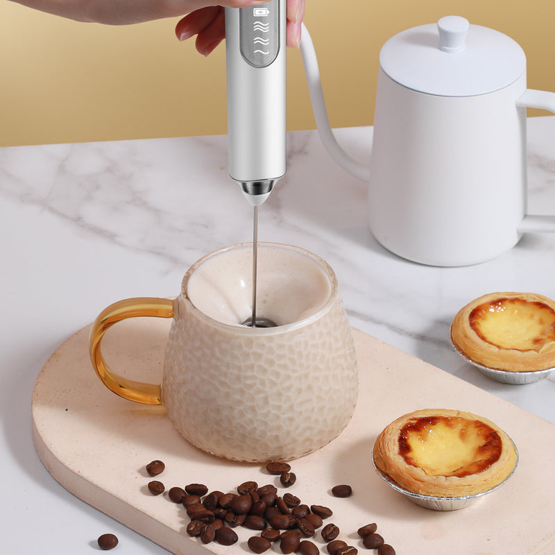 3-speed handheld milk frother quickly frothing milk in a glass mug for breakfast.